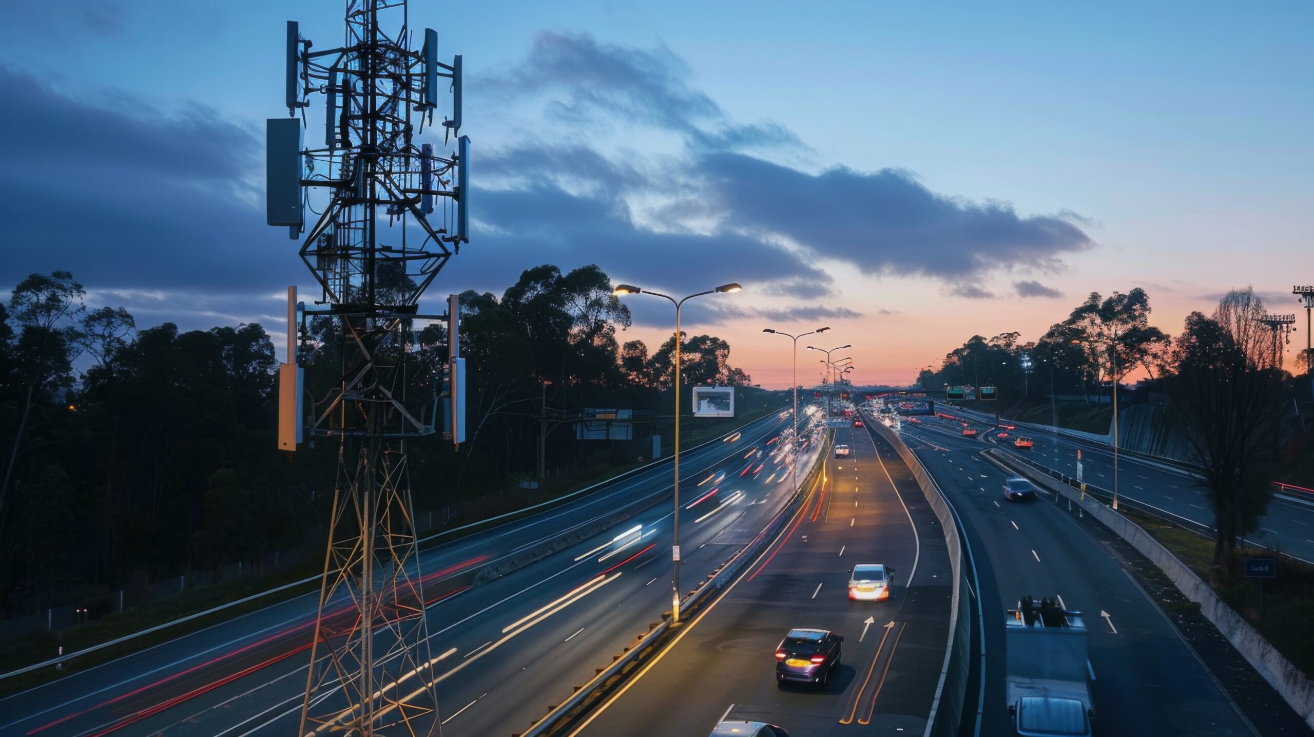 A cellphone tower with cars driving by